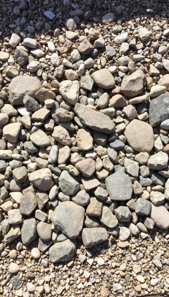 A well-lit, high-resolution photograph of a diverse collection of stones and gravel in the foreground, arranged in an aesthetically pleasing manner. The stones should range in size from small pebbles to larger boulders, with a variety of shapes, textures, and colors, including smooth river rocks, jagged quarried stones, and glistening quartz. The gravel should be spread evenly, providing a natural, earthy backdrop that complements the stones. The lighting should be natural, with soft shadows and highlights that accentuate the unique characteristics of each piece. The camera angle should be slightly elevated, providing a clear, unobstructed view of the arrangement, showcasing the beauty and versatility of these natural materials. A well-lit, high-resolution photograph of a diverse collection of stones and gravel in the foreground, arranged in an aesthetically pleasing manner. The stones should range in size from small pebbles to larger boulders, with a variety of shapes, textures, and colors, including smooth river rocks, jagged quarried stones, and glistening quartz. The gravel should be spread evenly, providing a natural, earthy backdrop that complements the stones. The lighting should be natural, with soft shadows and highlights that accentuate the unique characteristics of each piece. The camera angle should be slightly elevated, providing a clear, unobstructed view of the arrangement, showcasing the beauty and versatility of these natural materials.